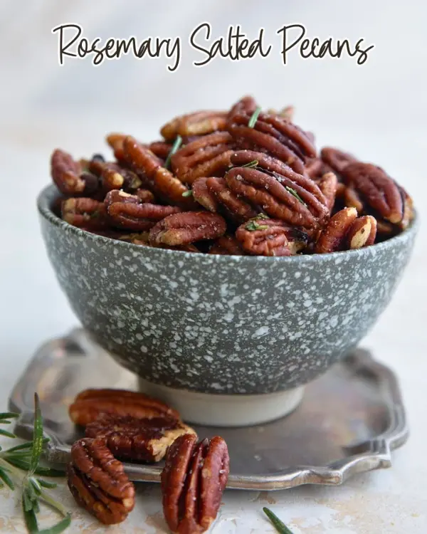 Bowl of salted rosemary pecans, a savory and flavorful snack.