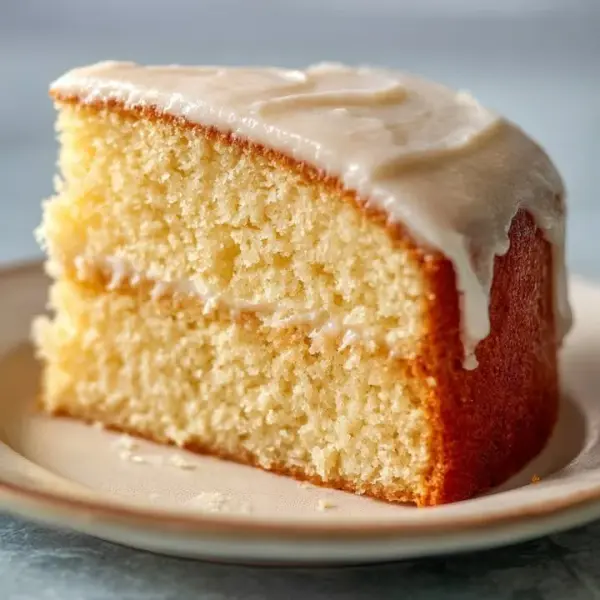 A freshly baked vanilla cake with frosting and decorative sprinkles on top.