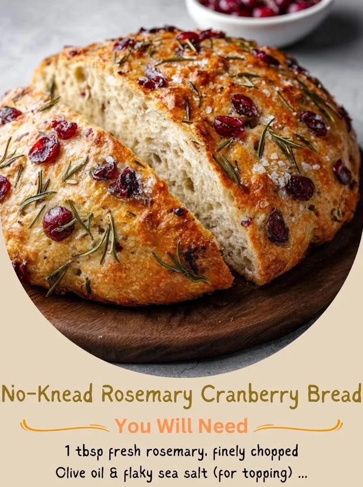 Loaf of no-knead rosemary cranberry bread on a wooden table